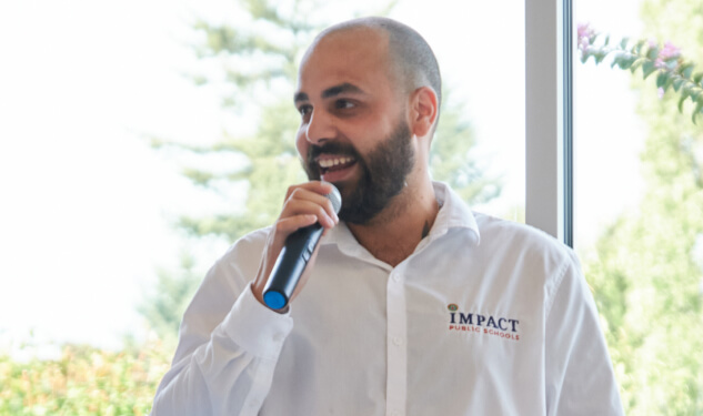 Man from Impact Schools Speaking into a Microphone